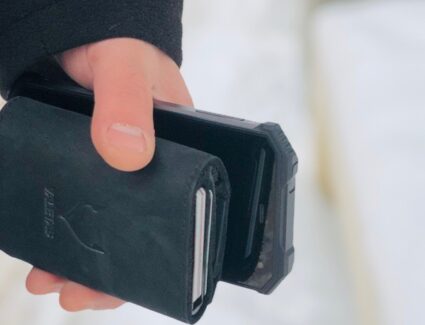 juoda odinė piniginė rankoje