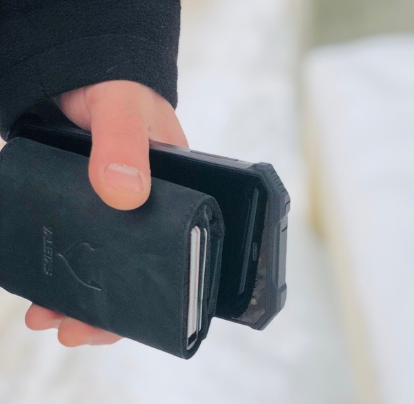 juoda odinė piniginė rankoje